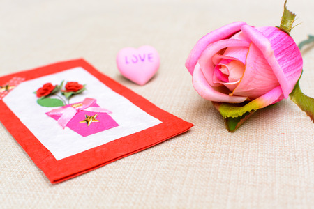 Close up of valentine card with rose and red heart shapeの写真素材