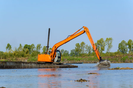 heavy duty, industrial excavator working in the river construction siteの写真素材