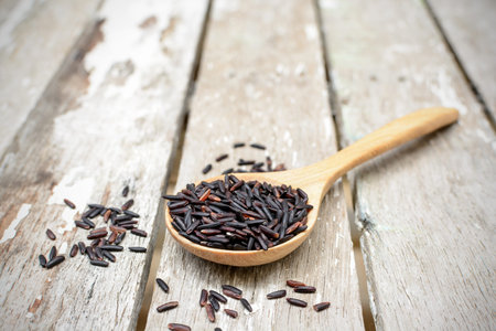 Close up of riceberry in spoon on wooden backgroundの写真素材