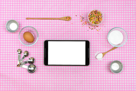 Baking raw ingredients with tablet on table clothの写真素材