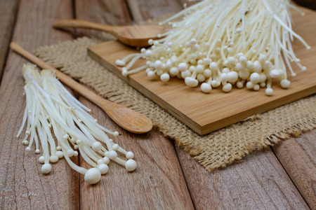Enoki mushroom with spoon on wooden table for cookingの写真素材