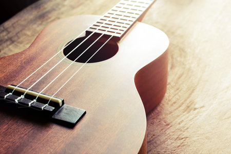 Close up of ukulele on old wood background with soft light, Vintage tone