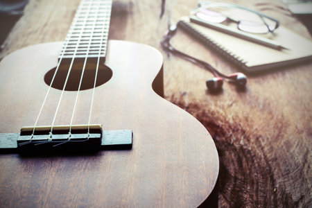 Close up of ukulele on old wood background with soft light, Vintage tone