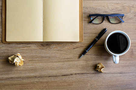 Cup of coffee with notebook on desk, workplace