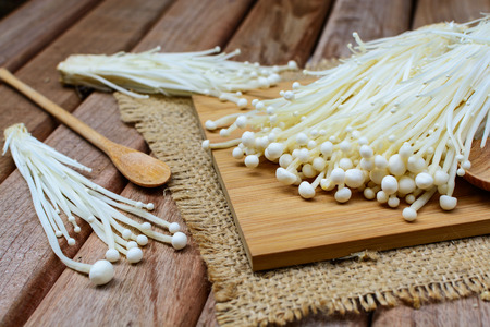 Enoki mushroom with spoon on wooden table for cookingの写真素材