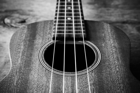 Close up of ukulele on old wood background with soft light, Vintage toneの写真素材