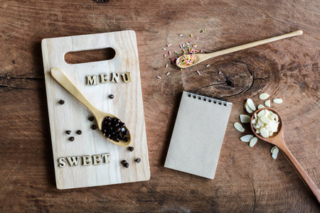 wooden spoon and fork with note on old wooden background and textured