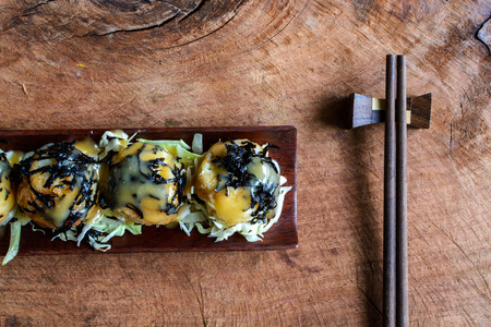 Takoyaki on wooden table with chopsticks, Japanese foodの写真素材