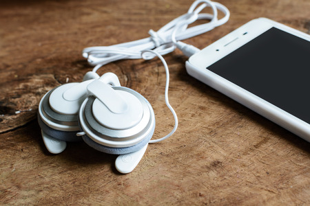Close up of earphone with smartphone on wooden tableの写真素材