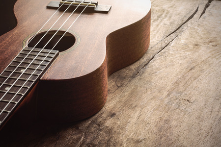 Close up of ukulele on old wood background with soft lightの写真素材