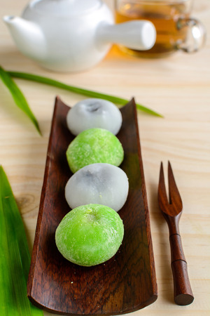Daifuku greentea and sesame filling with cup of tea on wooden tableの写真素材