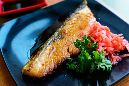 Close up of Salmon steak and ginger preserves in  black dishの写真素材