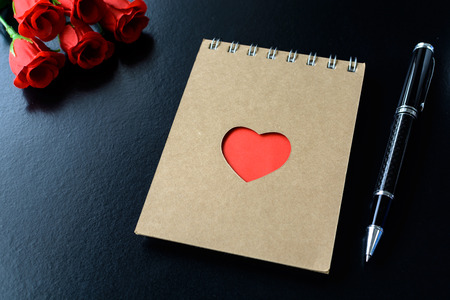 Red flower and red heart shape notepad  with penの写真素材