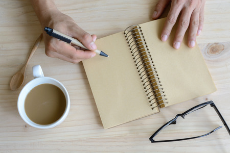 Cup of coffee with blank notebook on wooden deskの写真素材