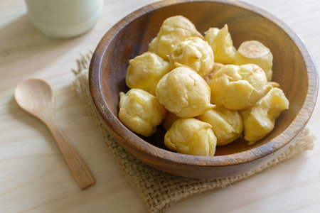 Choux pastry cream puffs with milk on wooden table