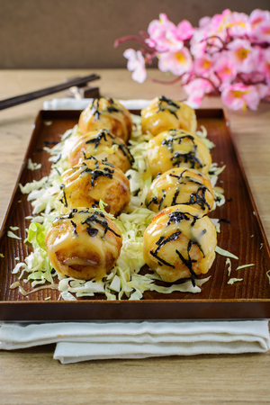 Close up of takoyaki on wooden table with chopsticks, Japanese foodの写真素材