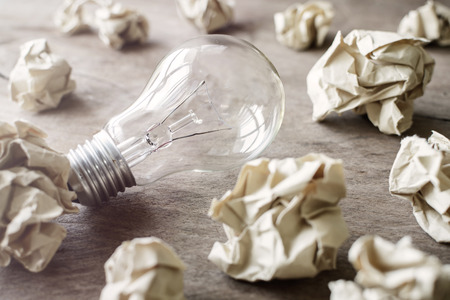 Crumpled paper balls on wooden desk, creative writing conceptの写真素材