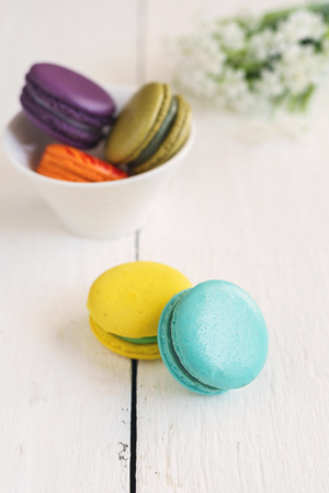 Colorful macaroons and a cup of coffee on white wooden tableの写真素材