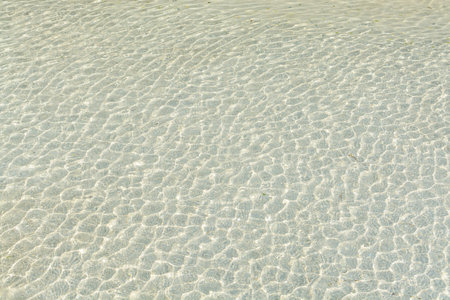 transparent water ripple and sunlight glare on white sand background