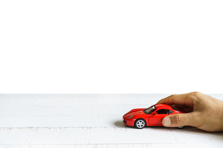 Car in hand on wooden table isolated on white background, Travel conceptの写真素材
