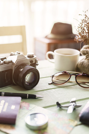 Retro camera with coffee and items on wooden table, Travel planningの写真素材