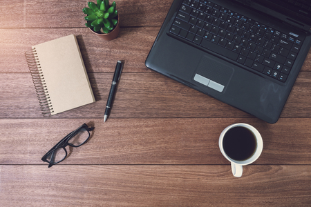 Laptop and cup of coffee on wooden desk with copy space, Top viewの写真素材