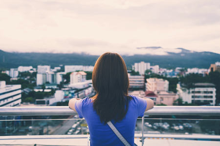 Hipster young girl looking the city on observation deck, Vintage toneの写真素材