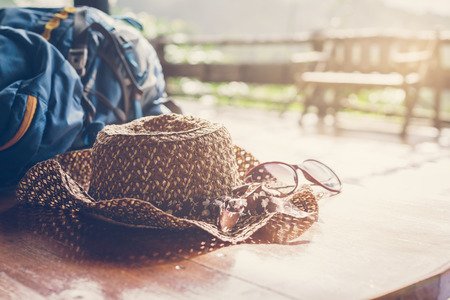 Travel backpack with hat and sunglasses on the wooden tableの写真素材