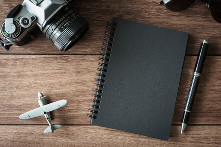 Retro camera with black notebook on wooden background and copy space, Top viewの写真素材