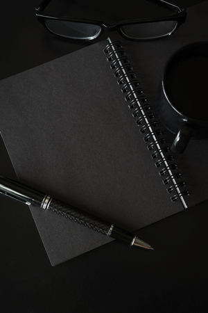 Black notebook with copyspace and cup of coffeeの写真素材
