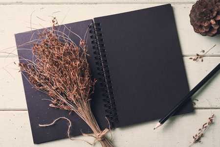 blank notebook and flower on old wooden table, Vintage toneの写真素材