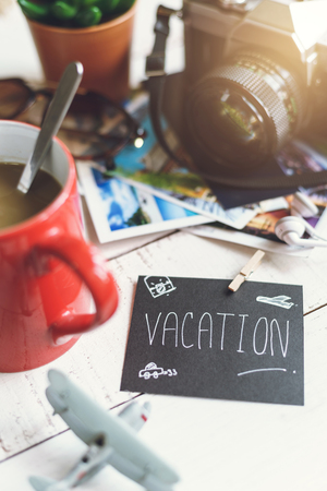 Travel preparations on white wooden table with cup of coffeeの写真素材