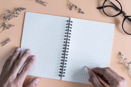 Blank notebook with flower and hand writing on color background, Top viewの写真素材