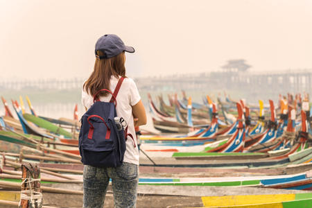 Young women traveler looking at U bein bridge. The longest wooden bridge in Mandalay, Myanmarの写真素材