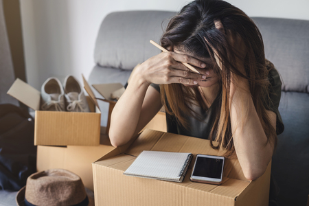 Stressed and frustrated asian business woman working online business by using smart phone and checking customer ordersの写真素材