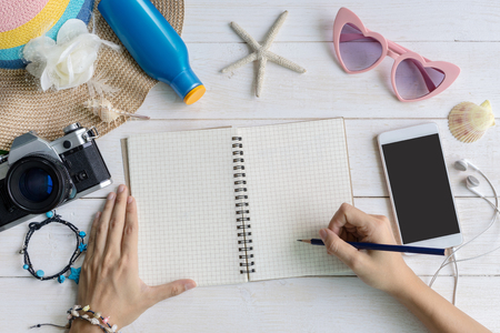 Women's casual clothes with accessories items and empty screen smart phone on white wooden background, Summer concept, Copy spaceの写真素材