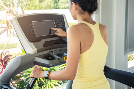 Young sport woman wearing smart watch running on treadmill at gym, Fitness, training lifestyle...