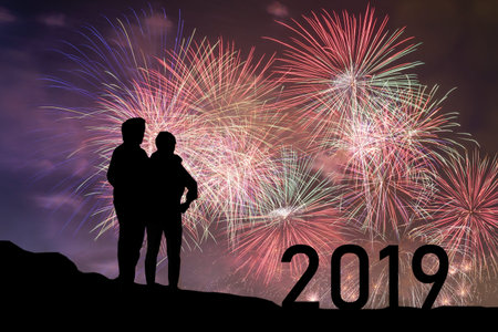 Couple looking colorful firework on the night sky, New Year celebration concept with copy space