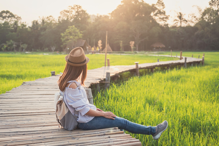 Young woman traveler looking at beautiful green paddy fieldの写真素材
