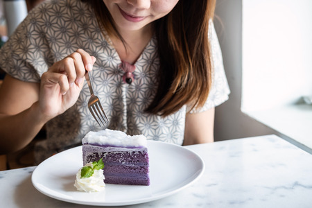 Young asian woman enjoy eating dessert in restaurantの写真素材