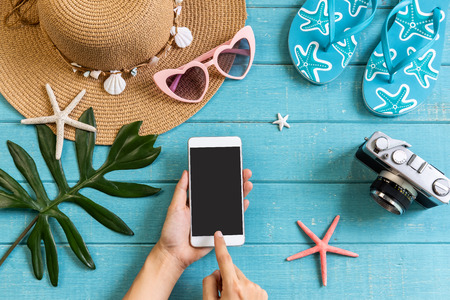 Travel accessories items with smart phone on wooden background, Summer vacation conceptの写真素材