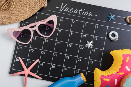 Calandar with camera and travel items, Summer vacation concept, Top viewの写真素材