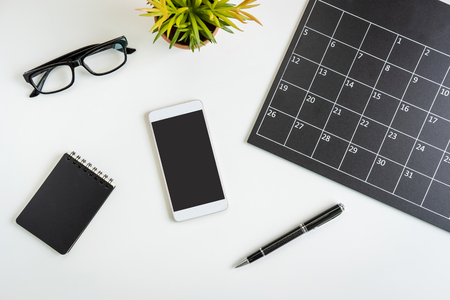 Planning calendar with smartphone on business desk office, Top viewの写真素材