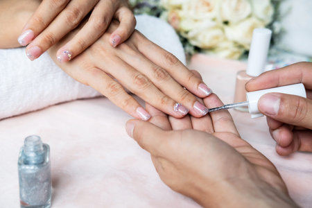 Beautiful manicure nails paint with glitter and varnish in nail salon