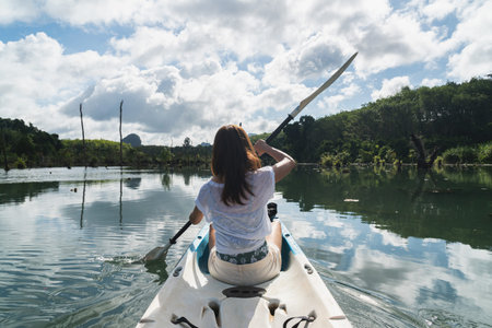 Young woman tourist paddling the kayak at klong root in Krabi, Thailand