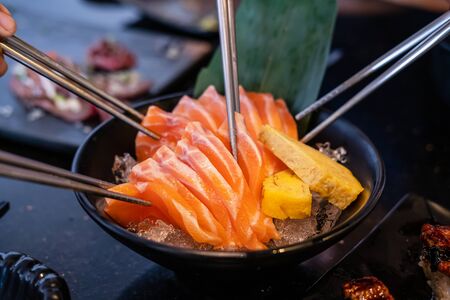 Group of people eating sashimi set in japanese restaurantの写真素材