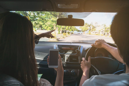 young couple traveler using gps navigation in smartphone on roadtrip