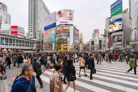 TOKYO, JAPAN - February 15, 2020: Crowds of people crossing road at Shibuya Crossing, One of the world's most used pedestrian scrambles in Tokyo, Japanのeditorial素材