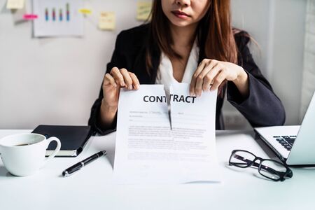 Business woman tearing contract at her office, Breaking contract conceptの写真素材