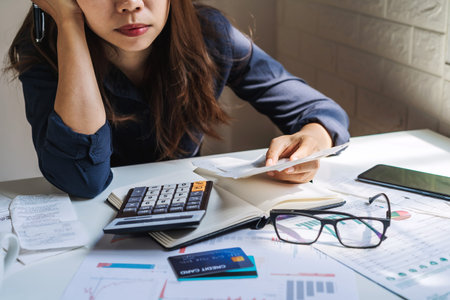 Stressed young woman checking bills, taxes, bank account balance and calculating expenses in the...